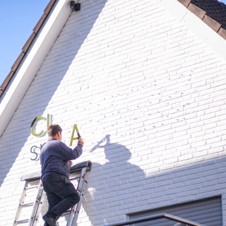 Aufängung Beschriftung Clappertons Speisekammer Fassade, Männer bringen die Buchstaben an, ein A in der Hand