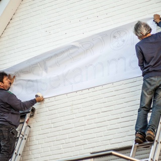 Aufängung Beschriftung Clappertons Speisekammer Fassade, Männer bringen ein Papier an, eine Vorlage